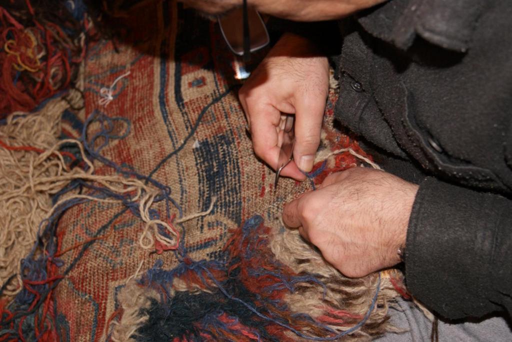 This is an image of one of our team weaving pile back into a rug on a loom.